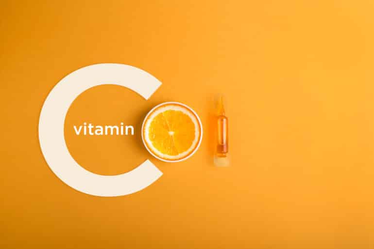 vitamin c graphic with an orange and vitamin c serum