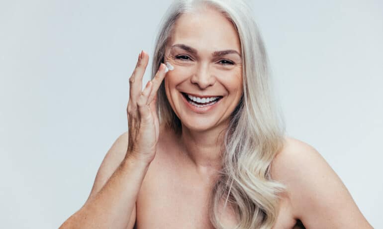 Older woman applying skincare
