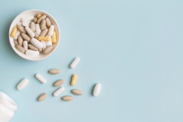 supplements in a white bowl on a blue background
