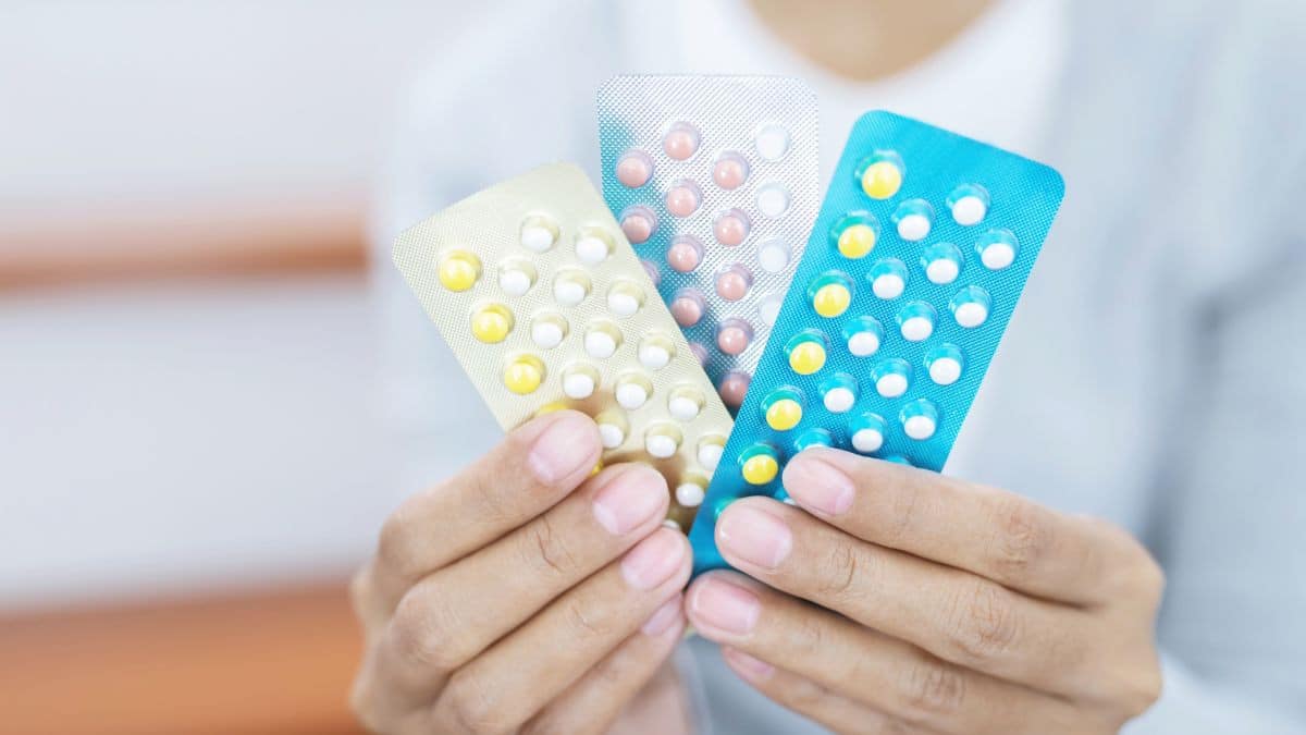 woman holding pills to prevent acne